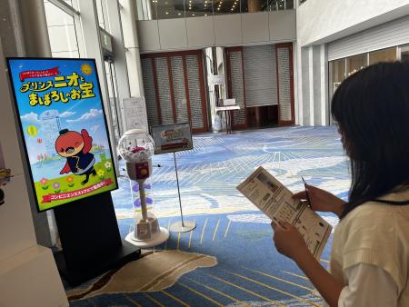 ソファに座り、冊子とスマートフォンを見ながら謎解きに取り組む参加者